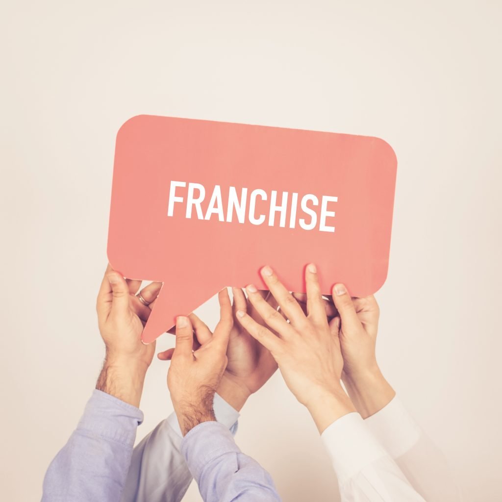 People Holding Franchise Written In Speech Bubble