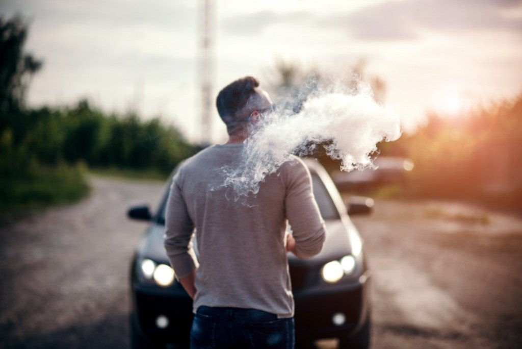 Man blowing vapor from e-cigarette