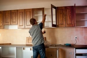 Man installing kitchen cabinets