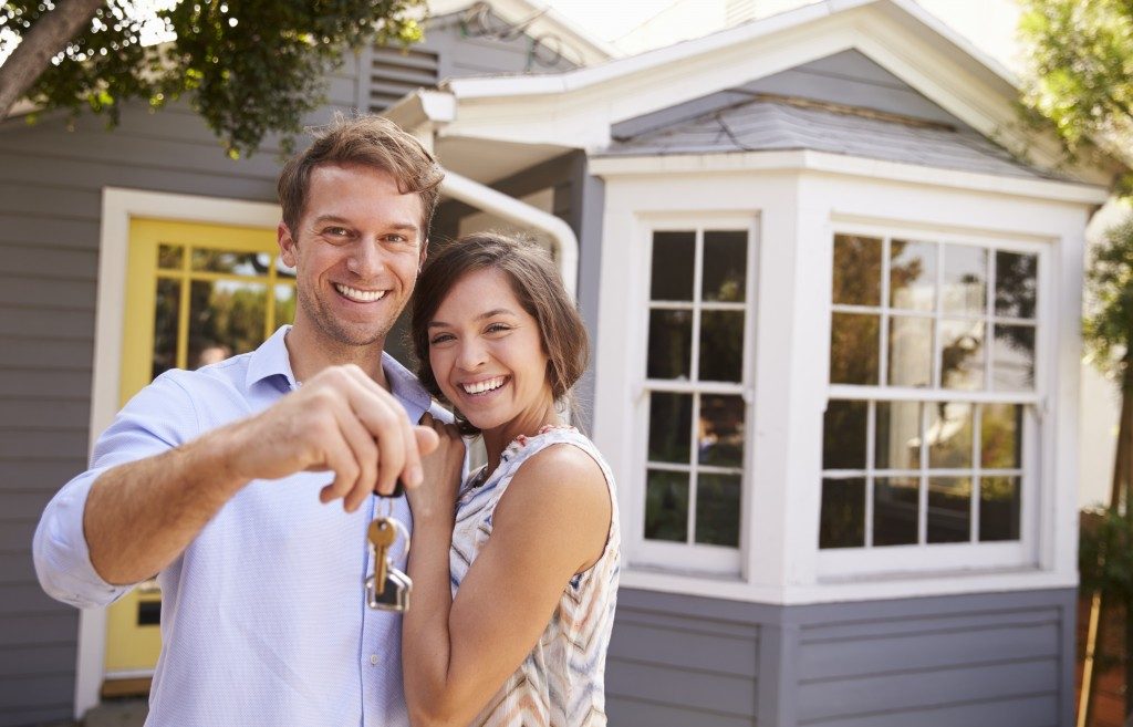 Couple with keys outside new home