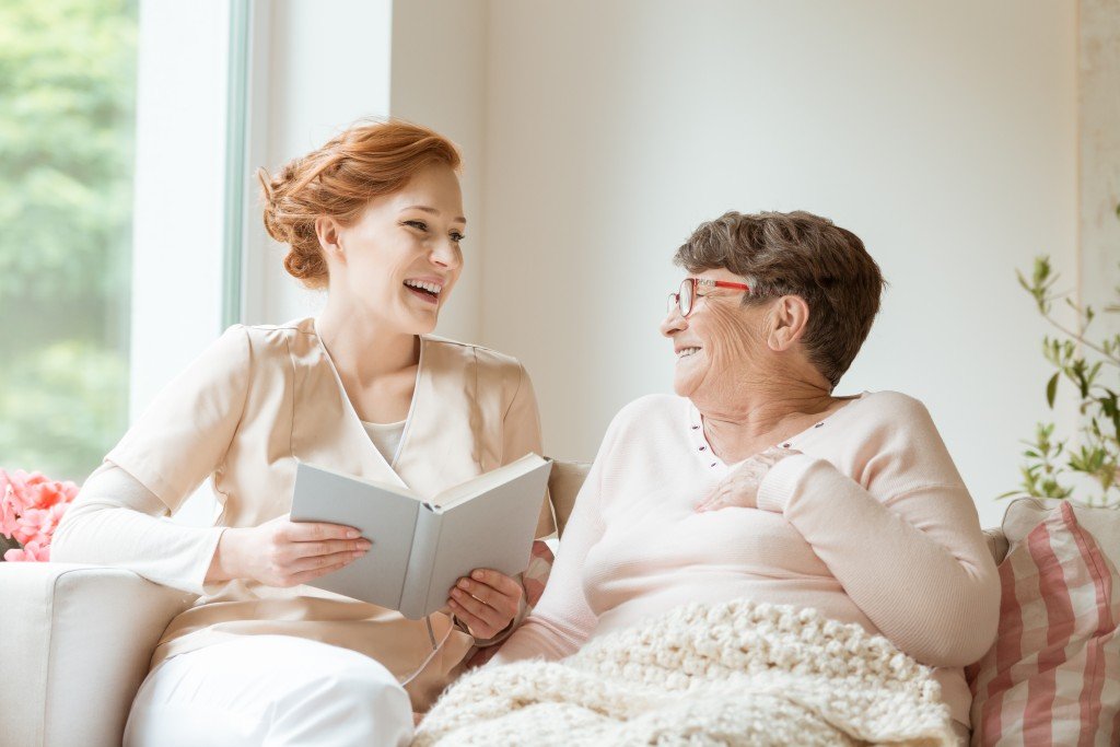 nurse reading to an elderly woman
