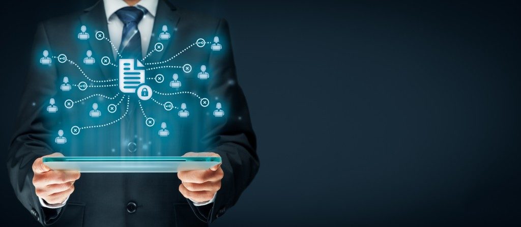 tablet held by man showing data icons