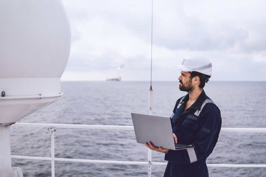 Man working on the boat with laptop