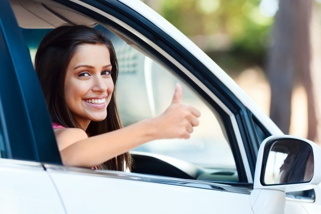 Woman driver with her thumb up